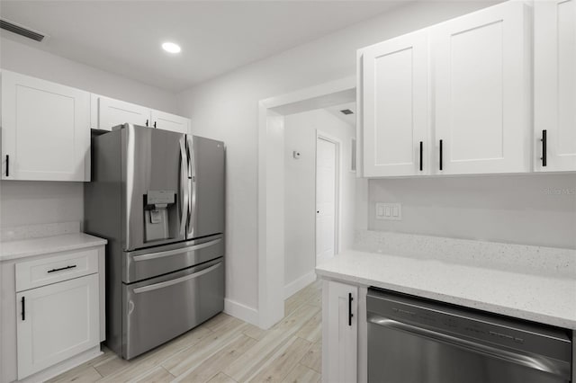 2157 20th Ave SW, Largo, FL 33774 - kitchen featuring appliances with stainless steel finishes, white cabinetry, light wood-type flooring, baseboards, and recessed lighting