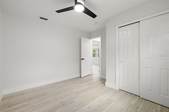 2157 20th Ave SW, Largo, FL 33774 - unfurnished bedroom featuring light wood-style flooring, a closet, baseboards, and a ceiling fan
