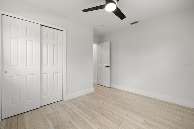 2157 20th Ave SW, Largo, FL 33774 - unfurnished bedroom featuring light wood-type flooring, baseboards, a closet, and a ceiling fan