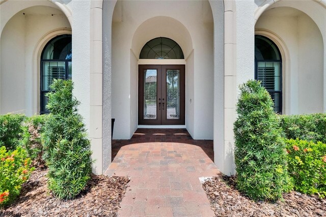 view of exterior entry with french doors and stucco siding
