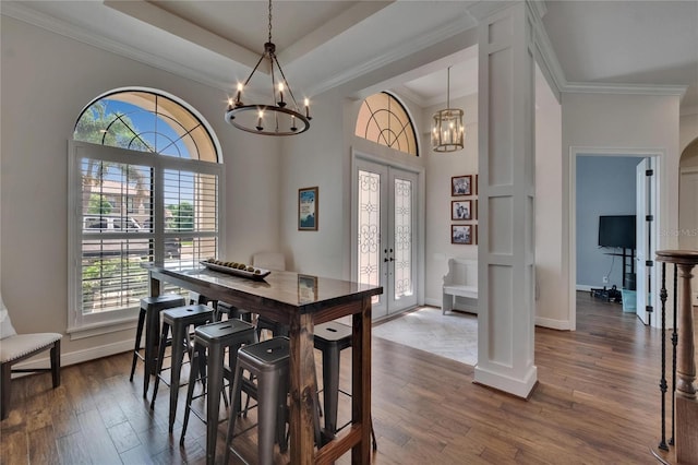 dining room featuring a chandelier, plenty of natural light, crown molding, dark wood-style floors, and baseboards
