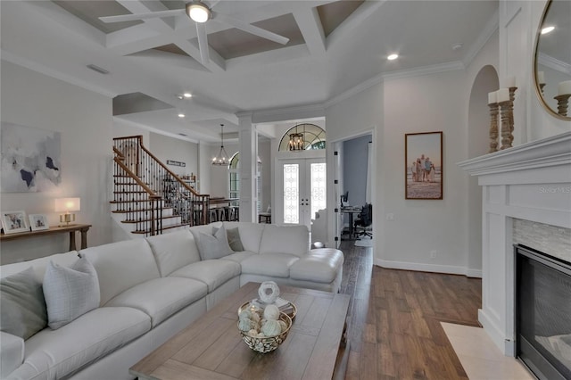 living area with coffered ceiling, wood finished floors, french doors, a chandelier, and beam ceiling