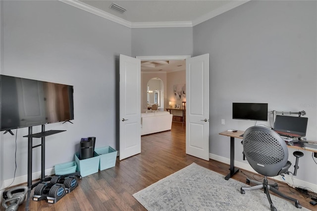 office area featuring arched walkways, ornamental molding, wood finished floors, and baseboards