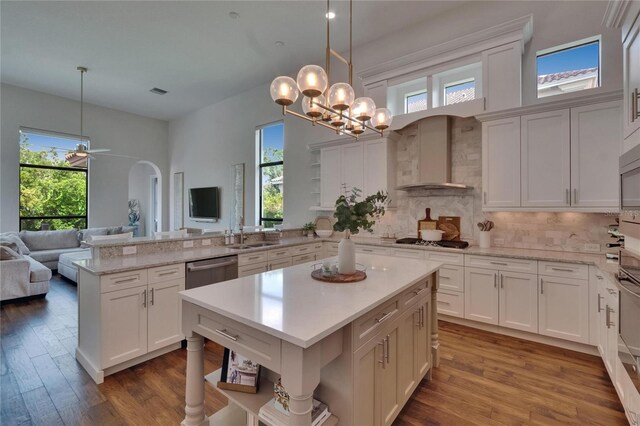 kitchen with open shelves, a peninsula, and plenty of natural light