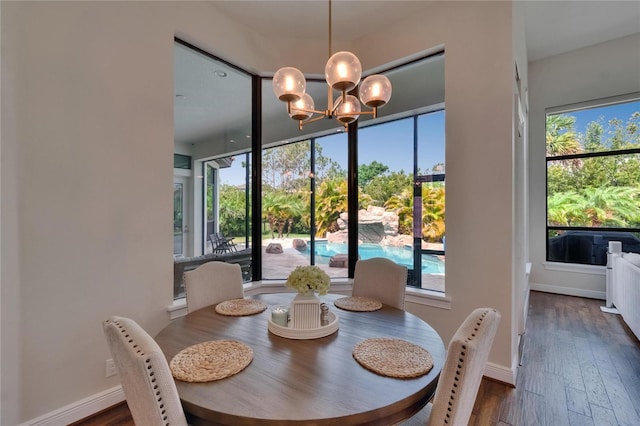 dining area featuring a chandelier, dark wood-style flooring, and plenty of natural light