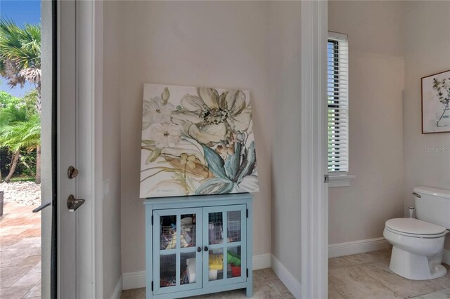 bathroom featuring toilet and baseboards