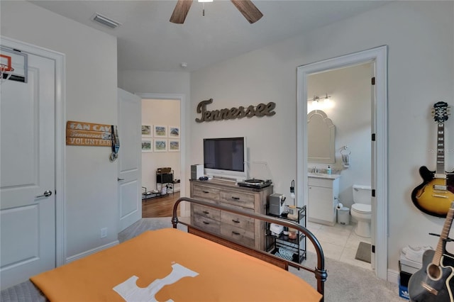 bedroom with ensuite bath, ceiling fan, and tile patterned floors