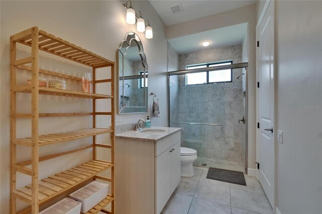 full bath featuring toilet, a stall shower, vanity, and tile patterned floors
