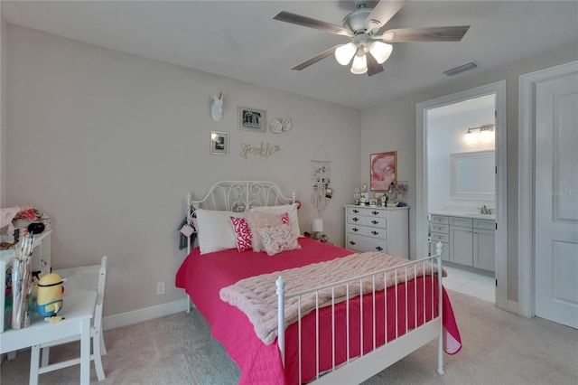bedroom with light carpet, a sink, baseboards, ensuite bathroom, and a ceiling fan