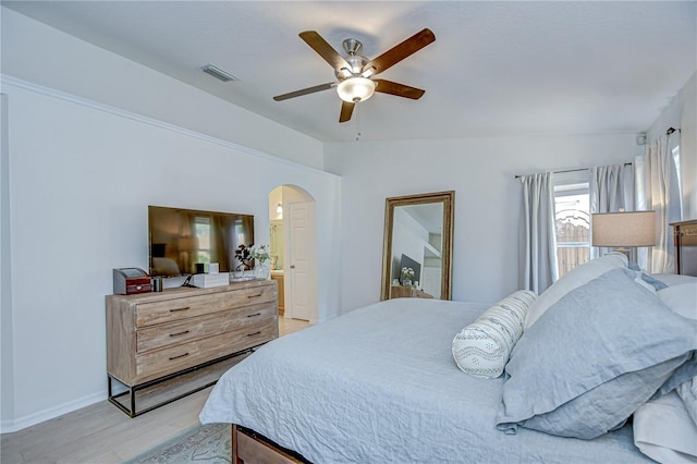 7107 Colonial Lake Dr, Riverview, FL 33578 - bedroom featuring arched walkways, light wood-type flooring, ceiling fan, baseboards, and ensuite bathroom
