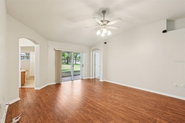 10150 Heather Sound Dr, Tampa, FL 33647 - spare room with arched walkways, wood finished floors, a ceiling fan, baseboards, and lofted ceiling