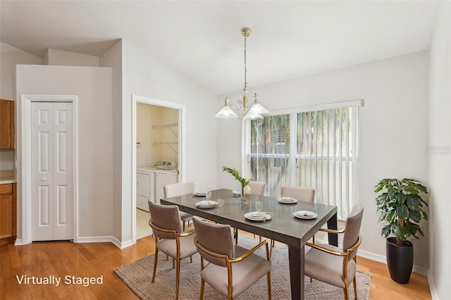 10150 Heather Sound Dr, Tampa, FL 33647 - dining area featuring independent washer and dryer, light wood-style floors, baseboards, lofted ceiling, and a chandelier