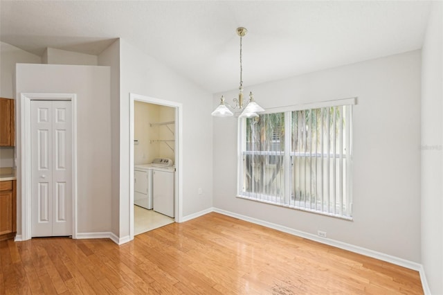 10150 Heather Sound Dr, Tampa, FL 33647 - unfurnished dining area featuring light wood finished floors, washing machine and clothes dryer, a chandelier, baseboards, and vaulted ceiling
