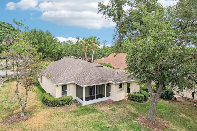 10150 Heather Sound Dr, Tampa, FL 33647 - back of house featuring a sunroom, a yard, stucco siding, and a shingled roof