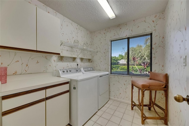 29903 Baywood Ln, Wesley Chapel, FL 33543 - laundry area featuring wallpapered walls, a textured ceiling, cabinet space, washer and clothes dryer, and light tile patterned floors