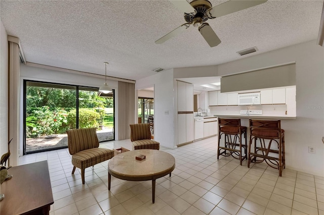 29903 Baywood Ln, Wesley Chapel, FL 33543 - living area featuring a ceiling fan, light tile patterned floors, and a textured ceiling