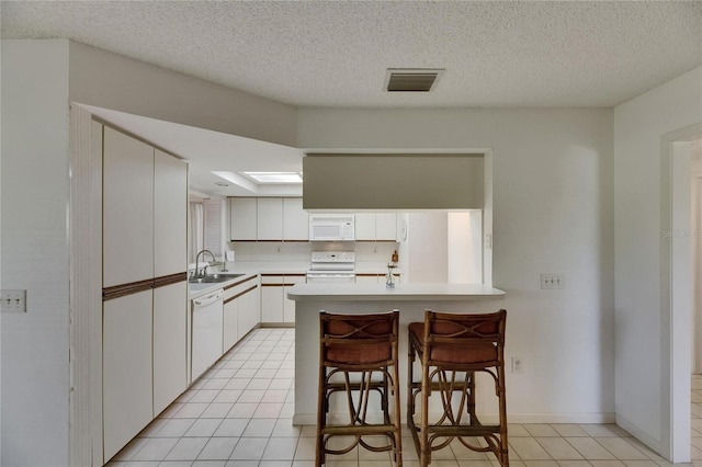 29903 Baywood Ln, Wesley Chapel, FL 33543 - kitchen with white appliances, a sink, light tile patterned floors, white cabinetry, and light countertops