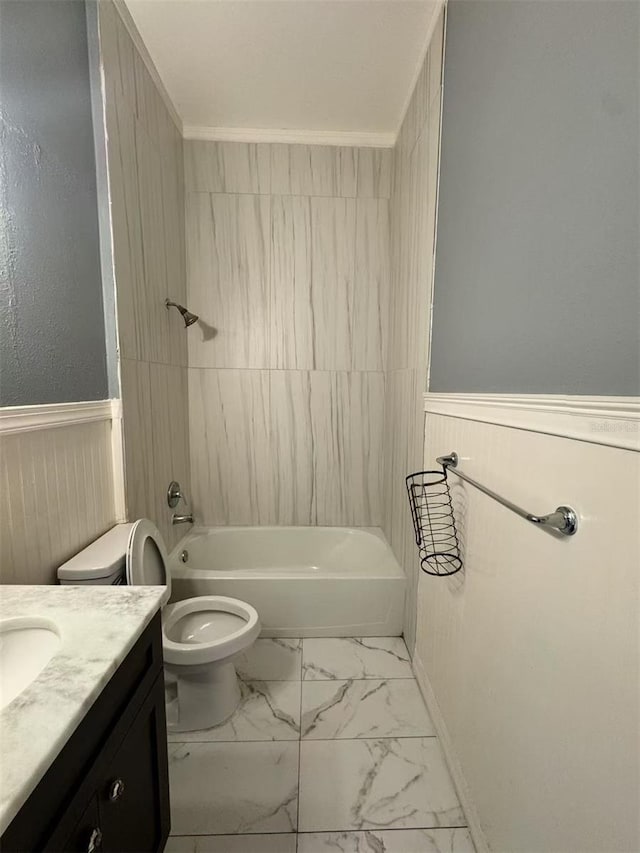 bathroom with wainscoting, toilet, vanity, marble finish floors, and bathing tub / shower combination