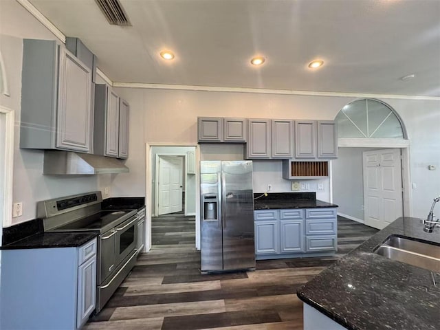 kitchen featuring stainless steel appliances, a sink, under cabinet range hood, gray cabinetry, and dark wood finished floors