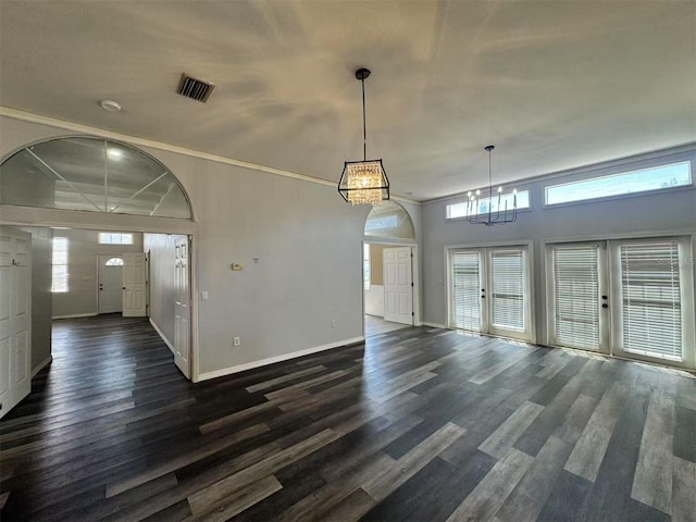 unfurnished dining area featuring a chandelier, dark wood-type flooring, and baseboards