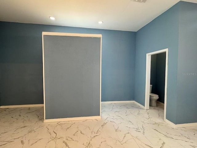 empty room with marble look tiles, baseboards, and recessed lighting