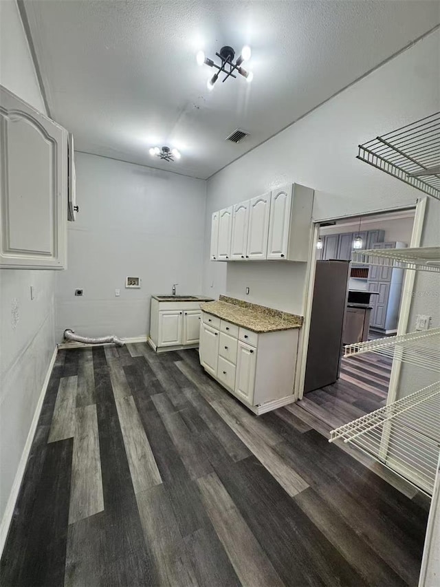 kitchen with dark wood finished floors, baseboards, white cabinets, and a sink