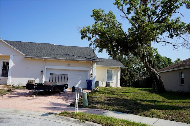 view of side of home featuring stucco siding, a garage, and a lawn
