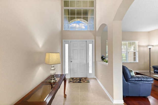 10837 Breaking Rocks Dr, Tampa, FL 33647 - foyer entrance with arched walkways, baseboards, and tile patterned floors