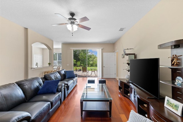 10837 Breaking Rocks Dr, Tampa, FL 33647 - living room featuring a ceiling fan, wood finished floors, a textured ceiling, and arched walkways