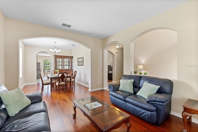 10837 Breaking Rocks Dr, Tampa, FL 33647 - living area with arched walkways, wood finished floors, a chandelier, and baseboards