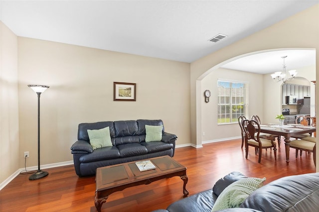 10837 Breaking Rocks Dr, Tampa, FL 33647 - living area with arched walkways, wood finished floors, baseboards, and a chandelier