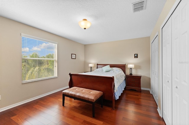 10837 Breaking Rocks Dr, Tampa, FL 33647 - bedroom with wood finished floors, baseboards, a textured ceiling, and multiple closets