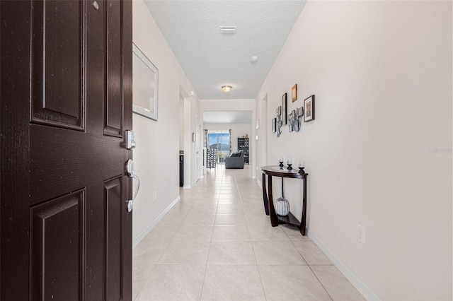 11917 Greenchop Pl, Riverview, FL 33579 - corridor featuring light tile patterned floors, baseboards, and a textured ceiling