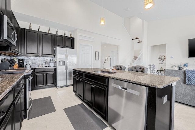 11917 Greenchop Pl, Riverview, FL 33579 - kitchen featuring stainless steel appliances, a sink, dark cabinets, light tile patterned flooring, and a high ceiling