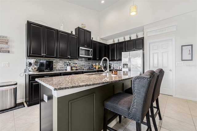 11917 Greenchop Pl, Riverview, FL 33579 - kitchen featuring appliances with stainless steel finishes, dark cabinetry, a sink, and decorative backsplash