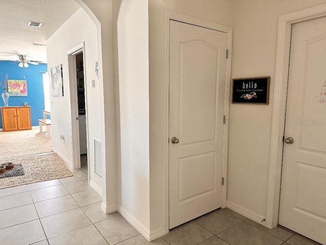 2987 Neverland Dr, New Smyrna Beach, FL 32168 - hall featuring arched walkways, light tile patterned floors, and baseboards
