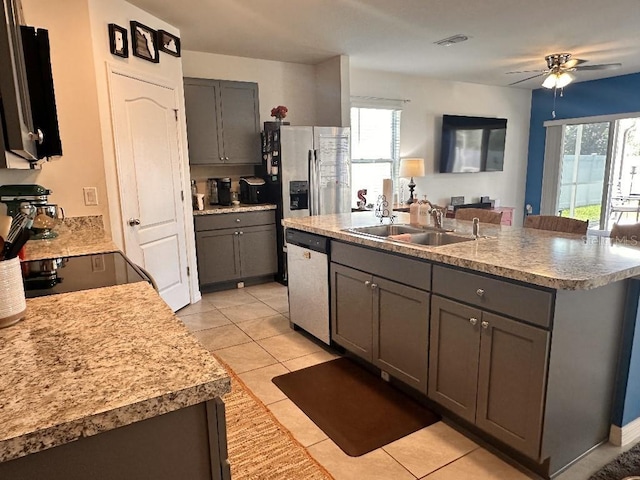 2987 Neverland Dr, New Smyrna Beach, FL 32168 - kitchen featuring stainless steel dishwasher, gray cabinets, a sink, a ceiling fan, and light tile patterned floors