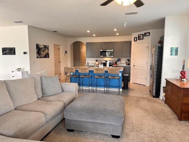 2987 Neverland Dr, New Smyrna Beach, FL 32168 - living area featuring arched walkways, ceiling fan, recessed lighting, light tile patterned floors, and light carpet