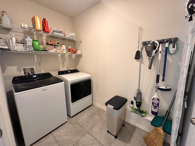 2987 Neverland Dr, New Smyrna Beach, FL 32168 - laundry room with washing machine and dryer, light tile patterned floors, and baseboards
