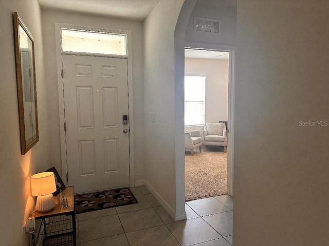 2987 Neverland Dr, New Smyrna Beach, FL 32168 - foyer entrance with light tile patterned flooring, arched walkways, and baseboards