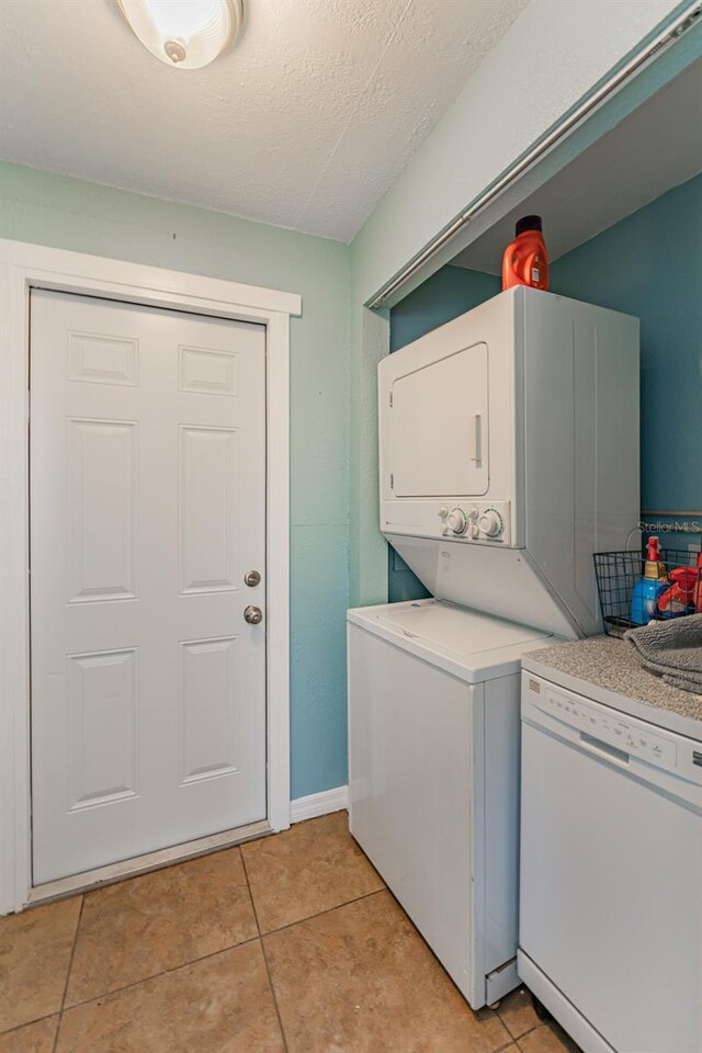 2035 29th Ave N, Saint Petersburg, FL 33713 - laundry room featuring stacked washer / dryer, light tile patterned floors, a textured ceiling, and baseboards
