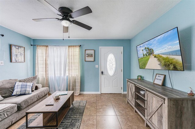 2035 29th Ave N, Saint Petersburg, FL 33713 - living room with a ceiling fan, a textured ceiling, light tile patterned flooring, and baseboards
