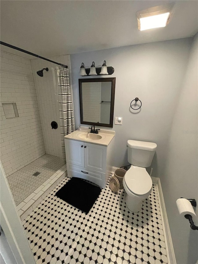 145 20th Ave SE, Saint Petersburg, FL 33705 - full bath featuring a tile shower, toilet, vanity, baseboards, and tile patterned floors
