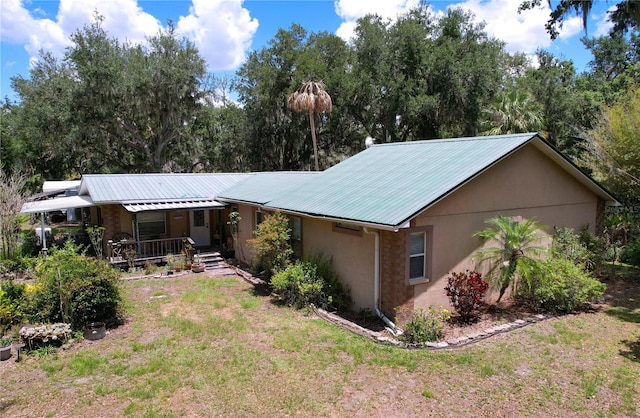3544 Porter Rd, Lithia, FL 33547 - view of front of home with covered porch, metal roof, stucco siding, and a front lawn