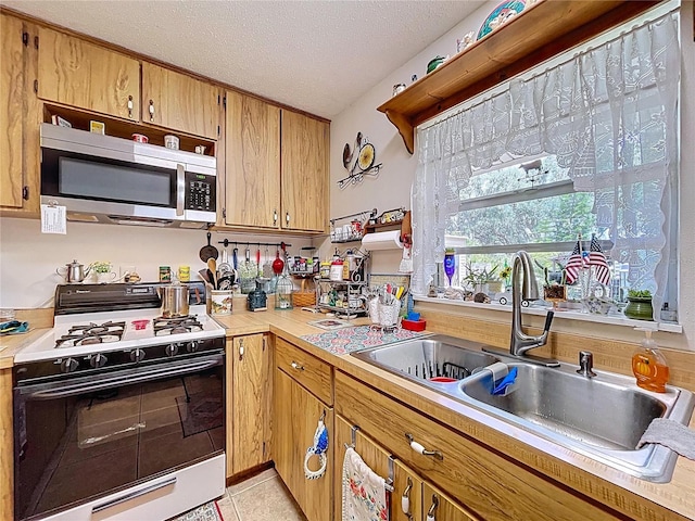 3544 Porter Rd, Lithia, FL 33547 - kitchen featuring gas range, stainless steel microwave, a sink, light countertops, and a textured ceiling