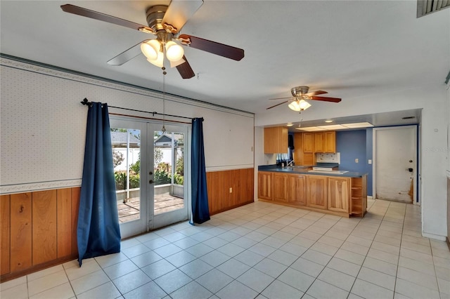 508 E Brentridge, Brandon, FL 33511 - kitchen featuring wainscoting, dark countertops, wooden walls, brown cabinets, and a ceiling fan
