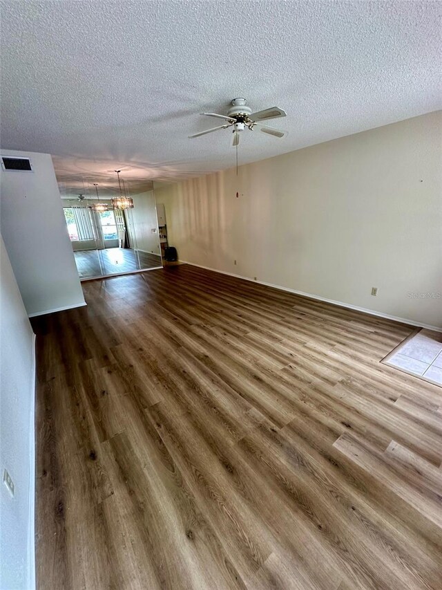 2360 Irish Ln Unit 16, Clearwater, FL 33763 - unfurnished living room with dark wood finished floors, a ceiling fan, and a textured ceiling