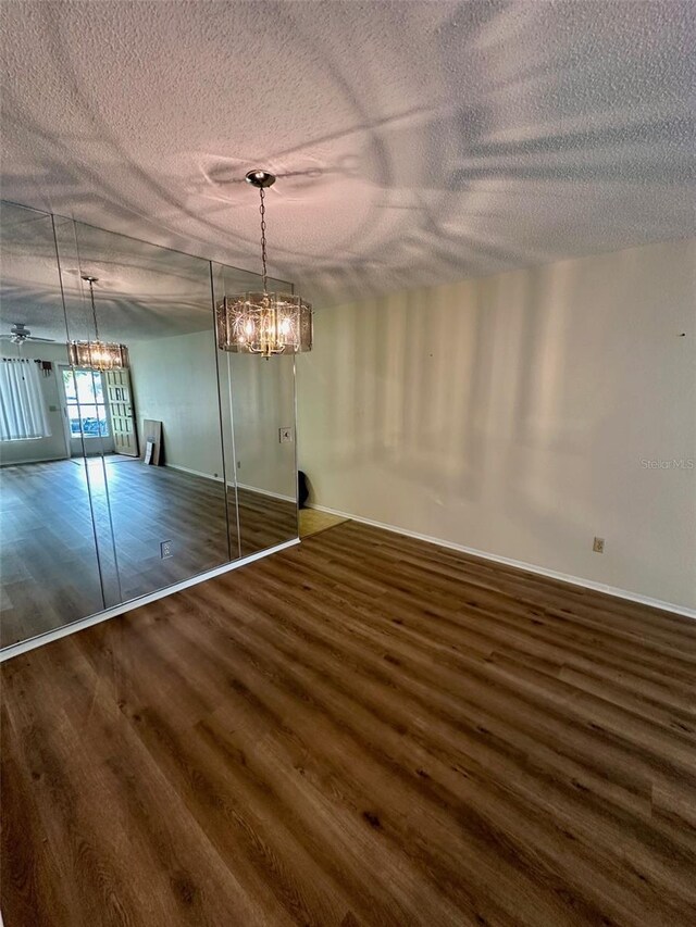 2360 Irish Ln Unit 16, Clearwater, FL 33763 - unfurnished dining area with wood finished floors, a textured ceiling, a chandelier, and baseboards