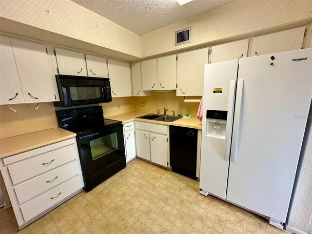 2360 Irish Ln Unit 16, Clearwater, FL 33763 - kitchen with black appliances, a sink, light countertops, light floors, and wallpapered walls