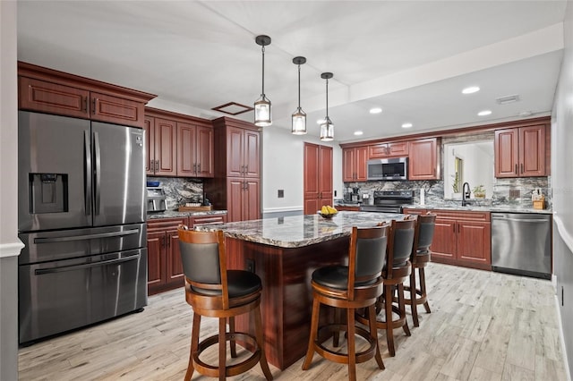 3413 W Kirby St, Tampa, FL 33614 - kitchen with appliances with stainless steel finishes, backsplash, light wood-style floors, recessed lighting, and a kitchen island